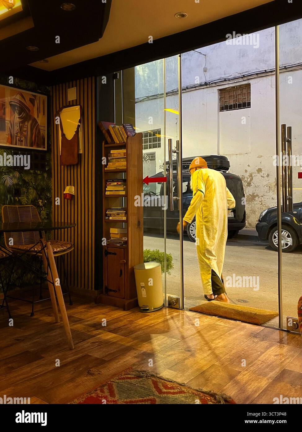 Vue intérieure d'un café marocain local à Tanger. ECLAIRAGE chaleureux, décor traditionnel et activités de rue à l'extérieur. Capturé le 2 octobre 2025. Banque D'Images