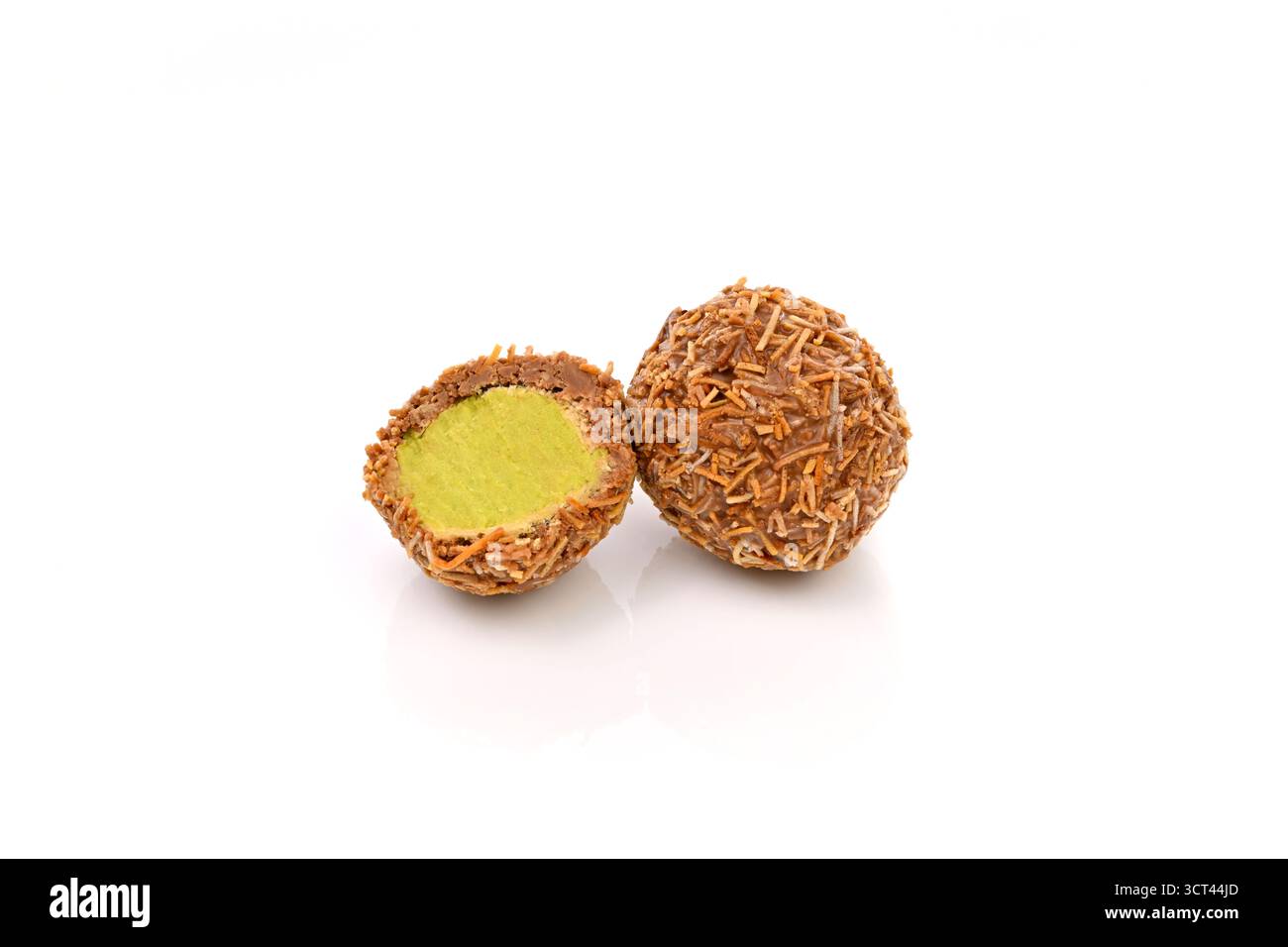 Un biscuit enrobé de chocolat Dubaï avec une garniture verte est montré avec la garniture verte enlevée. Le cookie est à moitié mangé et l'autre moitié est encore wh Banque D'Images