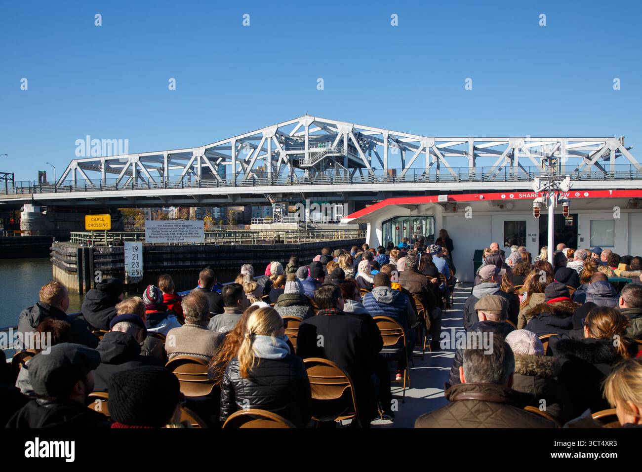 Groupe de touristes sur un bateau d'excursion et le pont de la troisième Avenue sur la rivière Harlem, Harlem, Manhattan, New York, États-Unis Banque D'Images