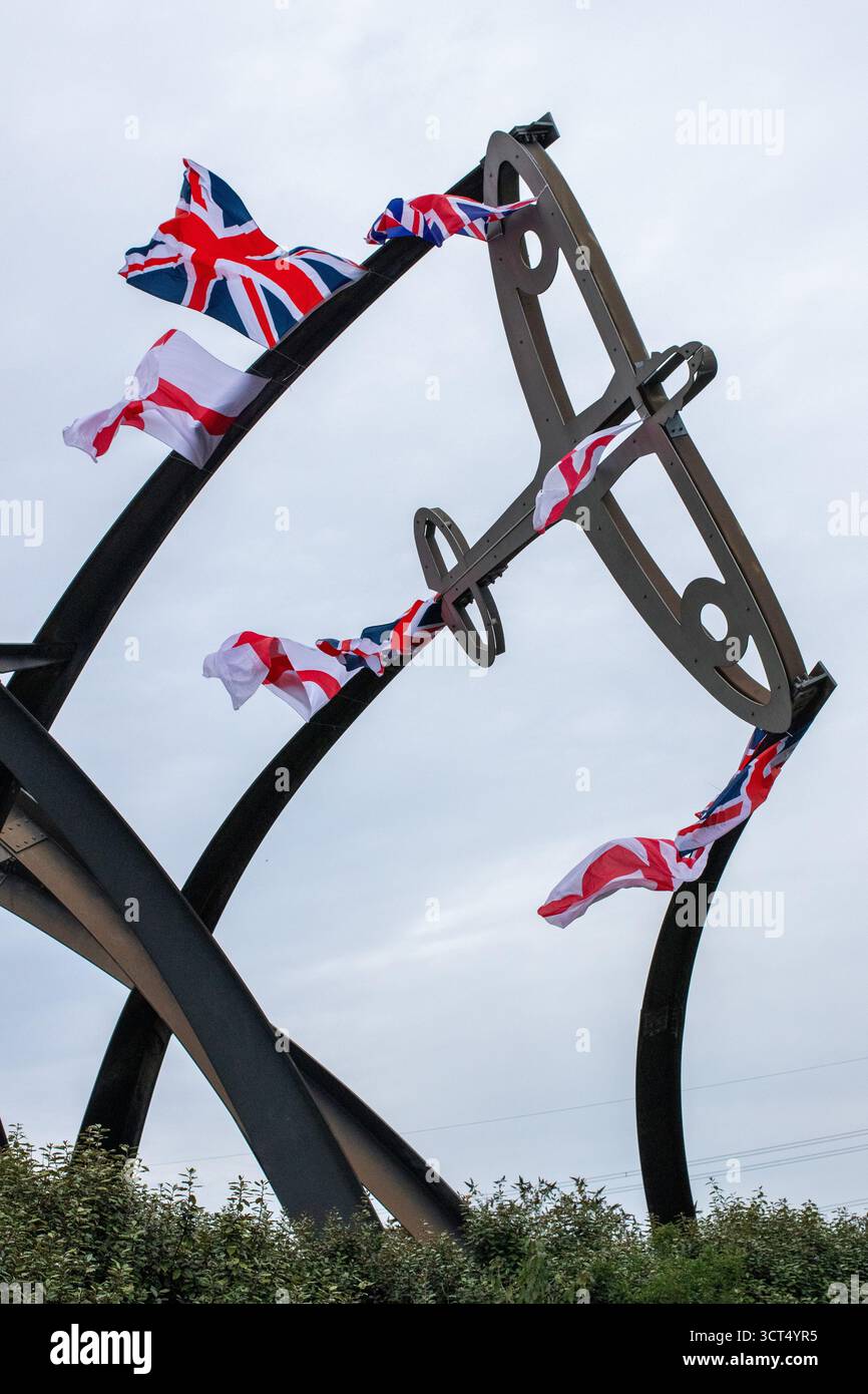 Des drapeaux patriotiques ont été placés sur l'île Spitfire à Birmingham, au Royaume-Uni. Les drapeaux de l'Union Jack et de l'Angleterre ont été drapés sur la sculpture Sentinel qui se trouve près du site où les emblématiques avions Spitfire ont été produits pendant la seconde Guerre mondiale. Sentinel est une sculpture de 16 mètres de haut (52 pieds) de Tim Tolkien, installée sur l'île Spitfire, un rond-point à l'intersection de la route Chester et de l'A47 Fort Parkway à l'entrée du domaine Castle Vale à Birmingham, en Angleterre. Banque D'Images