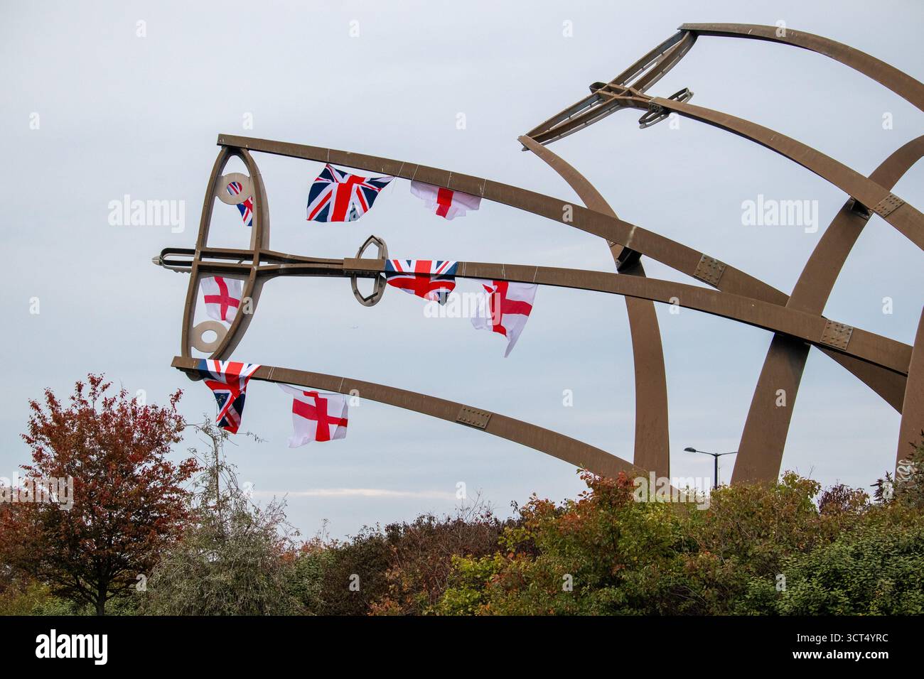 Des drapeaux patriotiques ont été placés sur l'île Spitfire à Birmingham, au Royaume-Uni. Les drapeaux de l'Union Jack et de l'Angleterre ont été drapés sur la sculpture Sentinel qui se trouve près du site où les emblématiques avions Spitfire ont été produits pendant la seconde Guerre mondiale. Sentinel est une sculpture de 16 mètres de haut (52 pieds) de Tim Tolkien, installée sur l'île Spitfire, un rond-point à l'intersection de la route Chester et de l'A47 Fort Parkway à l'entrée du domaine Castle Vale à Birmingham, en Angleterre. Banque D'Images