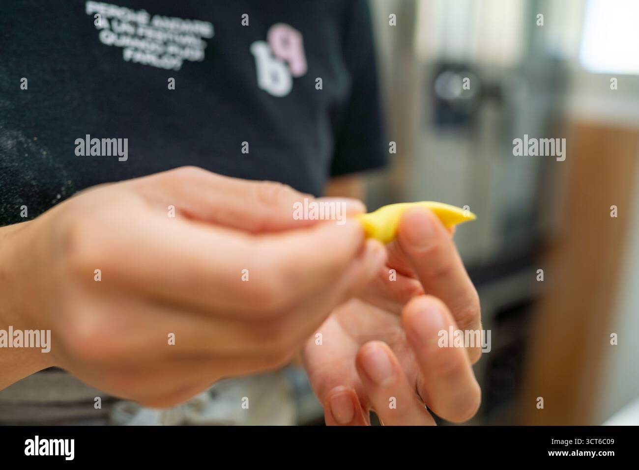 Piacenza, Italie - 25 septembre 2025 Une jeune femme caucasienne plie habilement de la pâte à pâtes fraîche pour créer de délicieux tortelli faits à la main un déli culinaire Banque D'Images