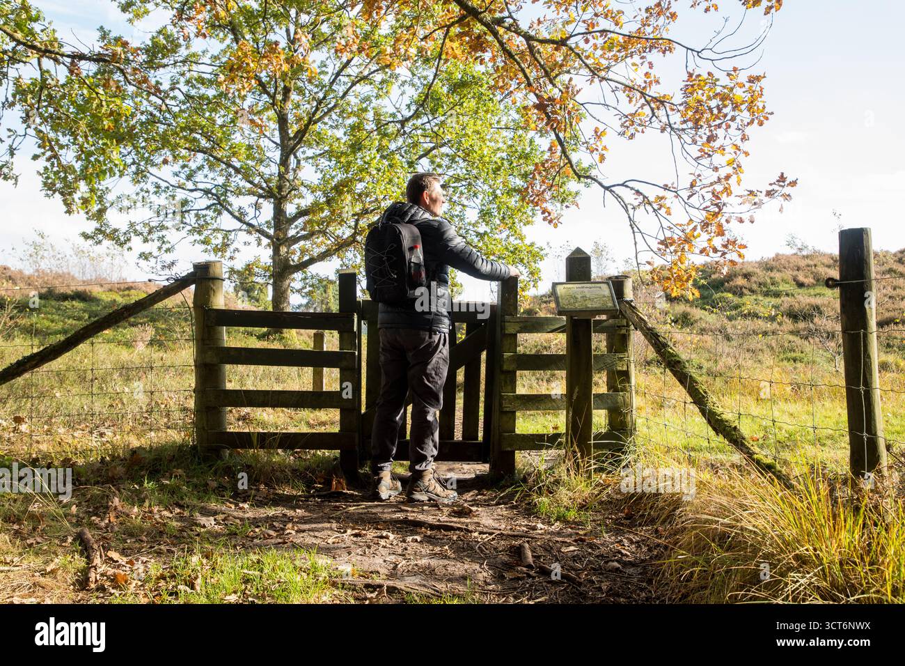 Homme prêt à ouvrir la porte du jardin pour le paysage de la santé une journée d'automne ensoleillée au Danemark Banque D'Images