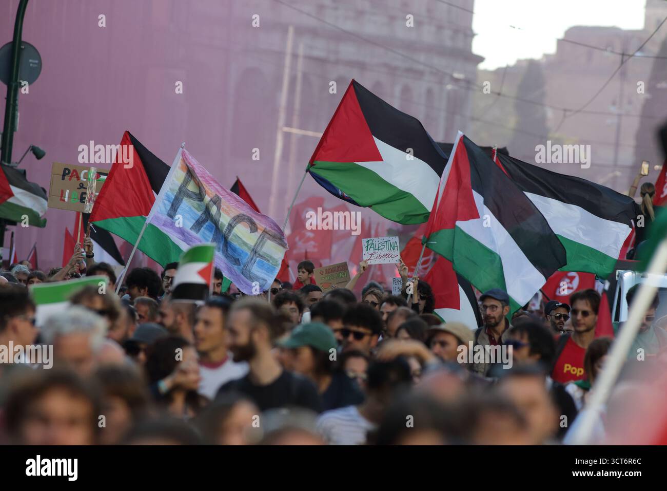 Drapeaux palestiniens agitant au-dessus de la foule avec la pancarte 'PACE' (paix) lors de la manifestation de Rome - 4 octobre 2025 Banque D'Images