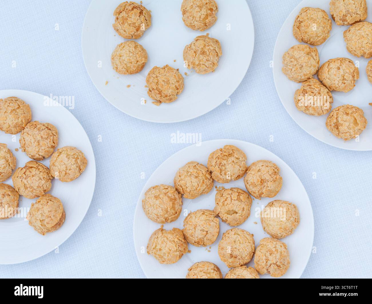 Pâtisseries dorées croustillantes au choux sur une assiette blanche, élégant dessert français servi lors d'un événement d'entreprise sur le toit à Paris. Banque D'Images