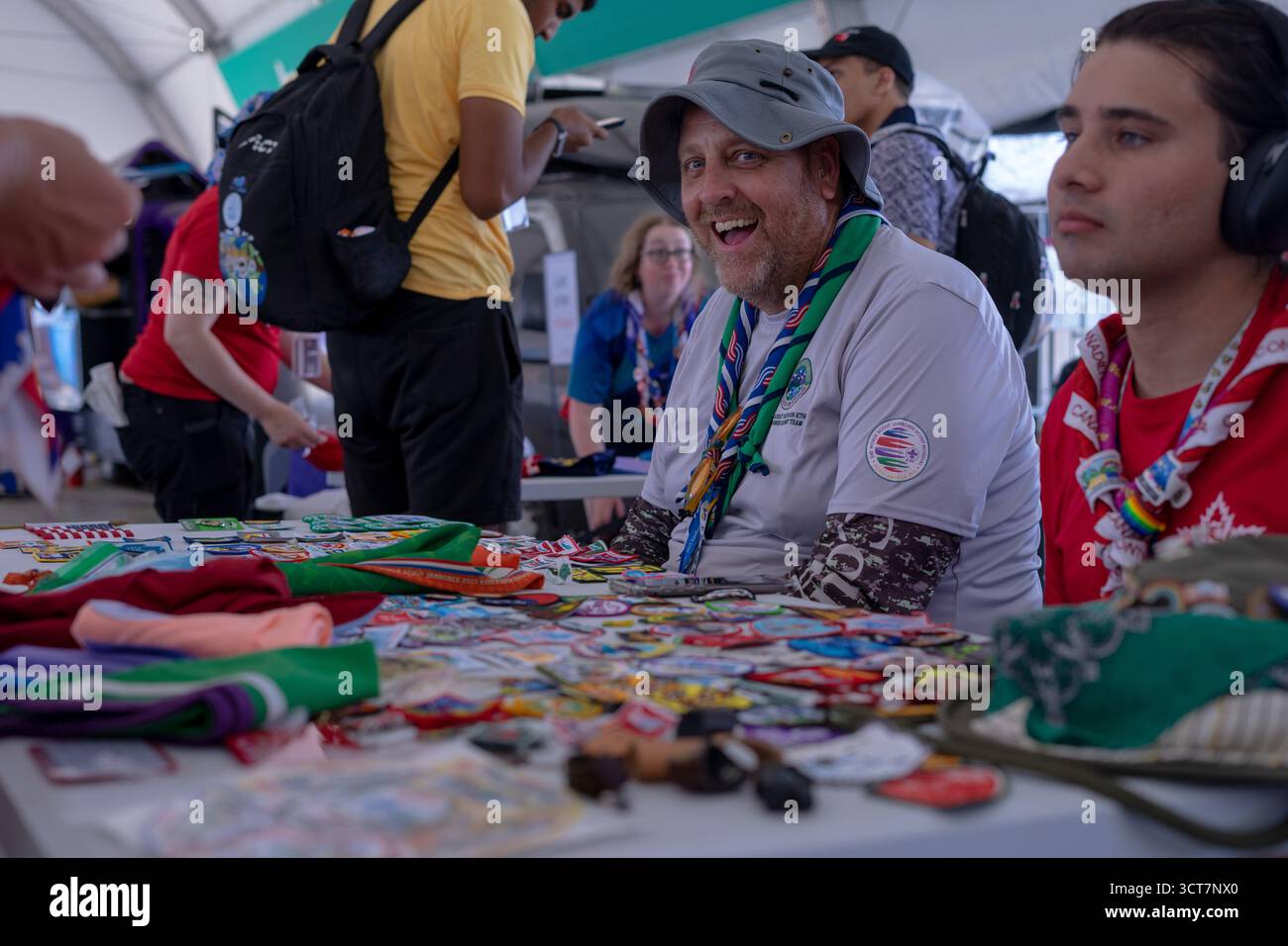Les leaders scout échangent des badges lors d'un jamboree international, célébrant l'amitié et l'esprit de scoutisme mondial. Banque D'Images