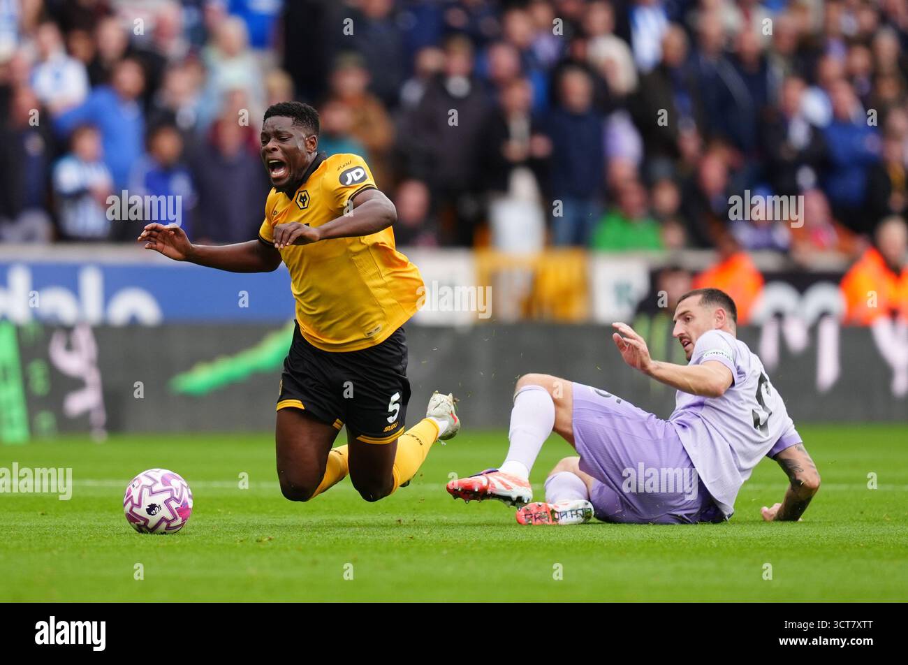 Marshall Munetsi des Wolverhampton Wanderers (à gauche) est déclenché par Lewis Dunk de Brighton et Hove Albion lors du match de premier League au Molineux Stadium, Wolverhampton. Date de la photo : dimanche 5 octobre 2025. Banque D'Images