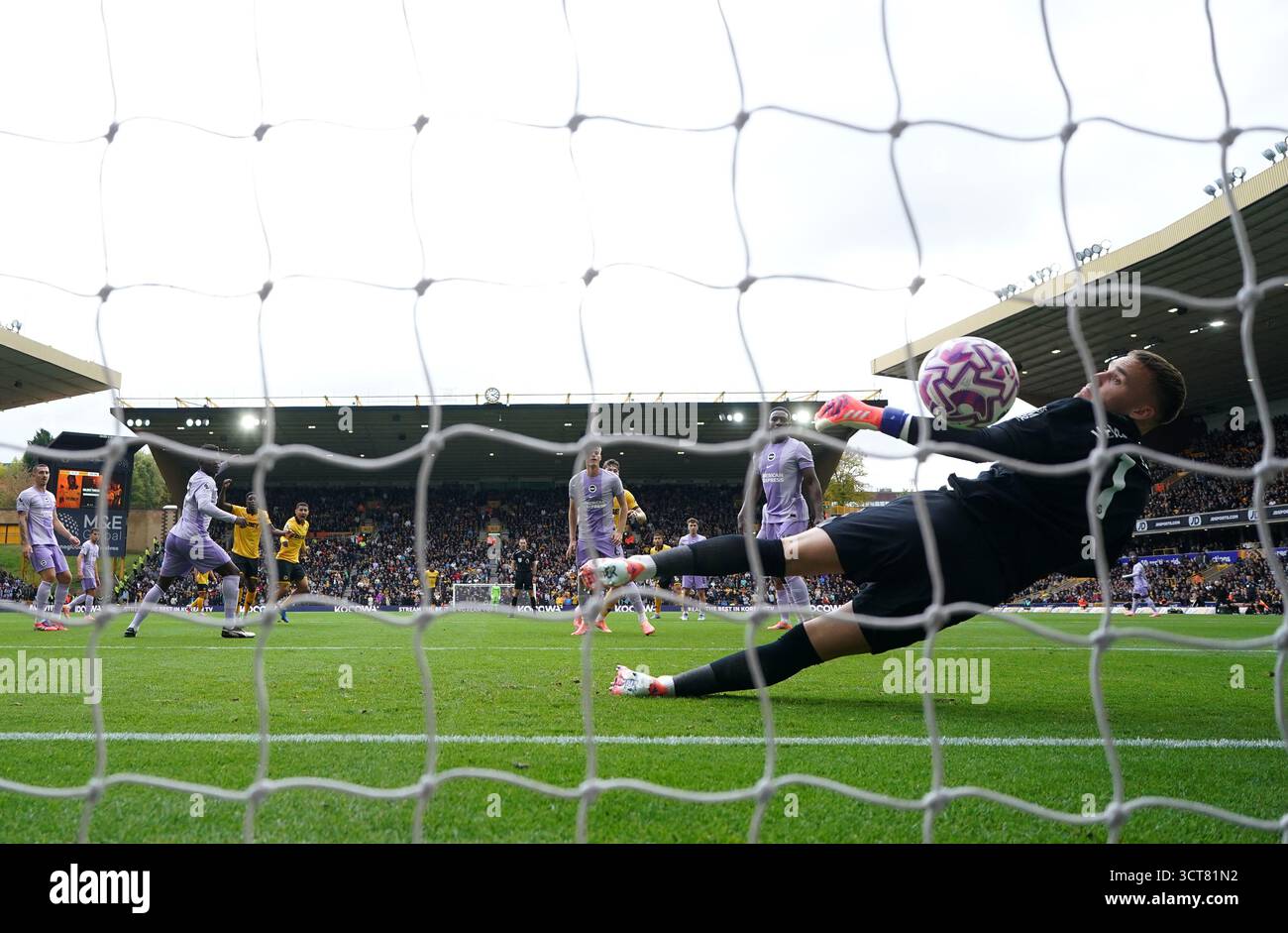 Marshall Munetsi des Wolverhampton Wanderers prend un tir qui est retourné par Brighton et Hove Albion gardien de but Bart Verbruggen pour leur premier but du match lors du match de premier League au Molineux Stadium, Wolverhampton. Date de la photo : dimanche 5 octobre 2025. Banque D'Images