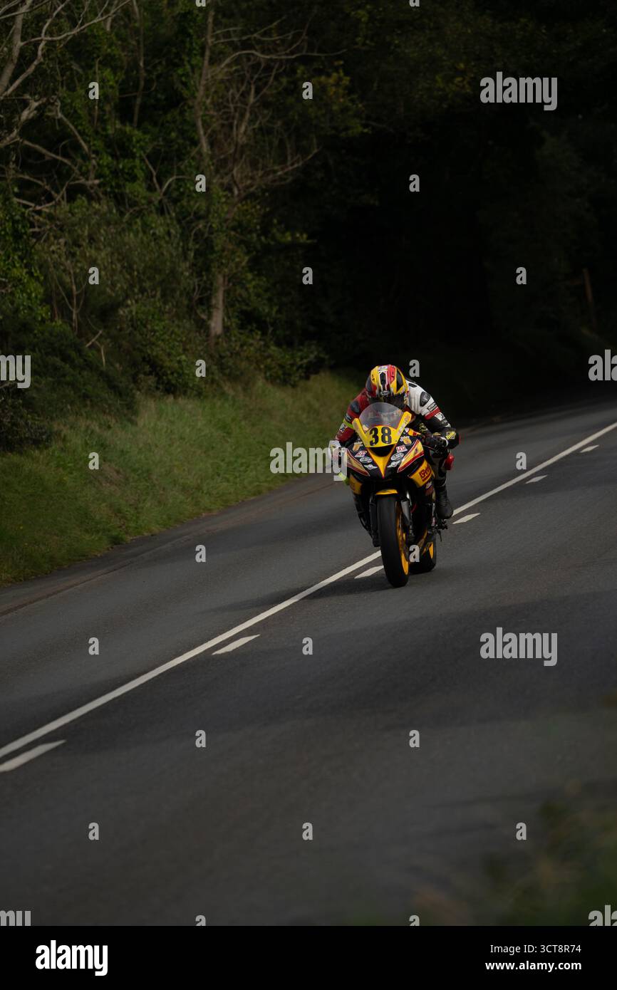 Motocycliste de course numéro 46 sur la route de campagne à travers la zone boisée Banque D'Images