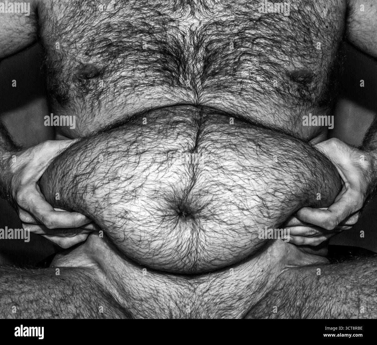 Homme obèse tenant la graisse du ventre dans les mains, noir et blanc gros plan image soulignant le corps en surpoids, problème de santé et problème de style de vie. Banque D'Images
