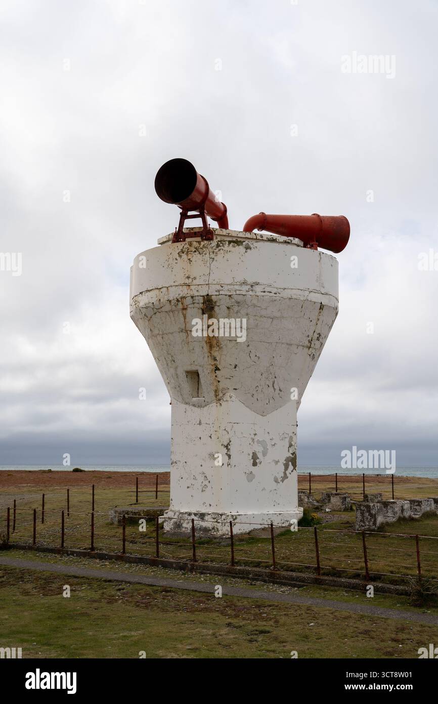 Tour de corne de brume blanche altérée avec des cornes rouges contre le ciel nuageux sur les prairies côtières Banque D'Images