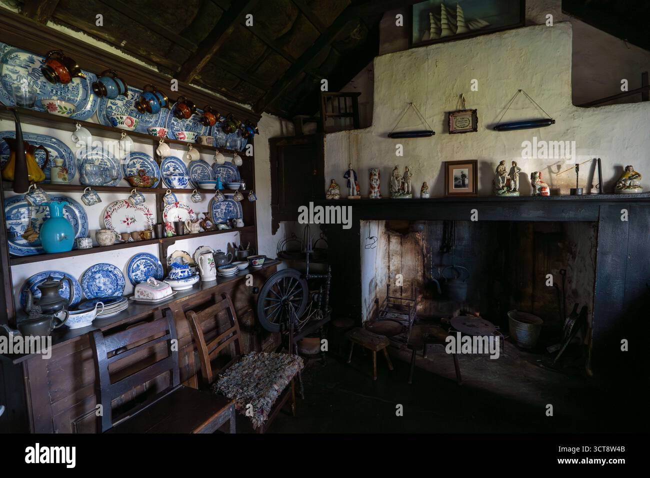 Intérieur traditionnel de la cuisine de cottage Manx avec commode en porcelaine bleue et cheminée en pierre Banque D'Images