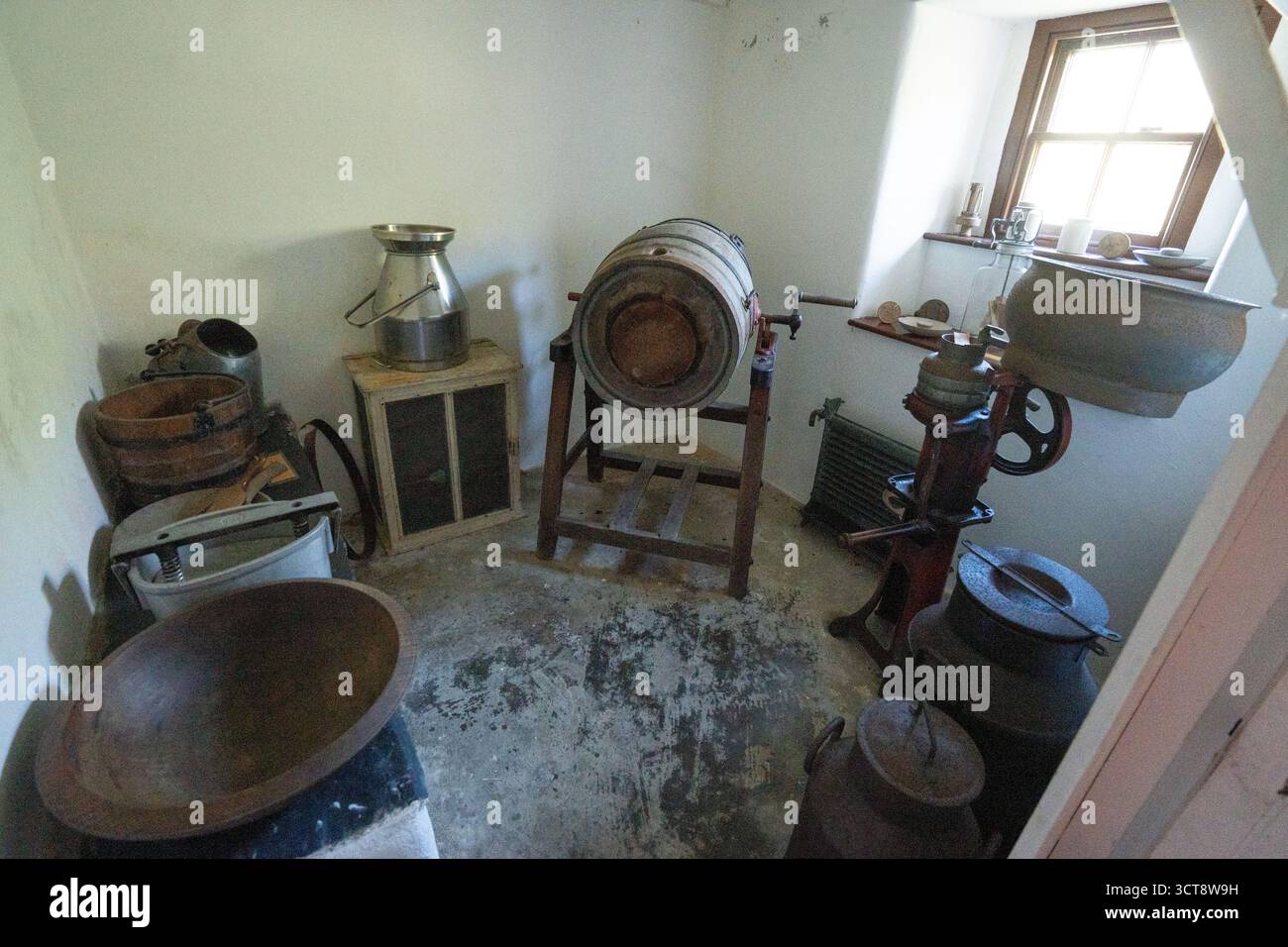 Salle de laiterie traditionnelle de ferme avec des barbes de lait vintage et du matériel de fabrication de beurre Banque D'Images