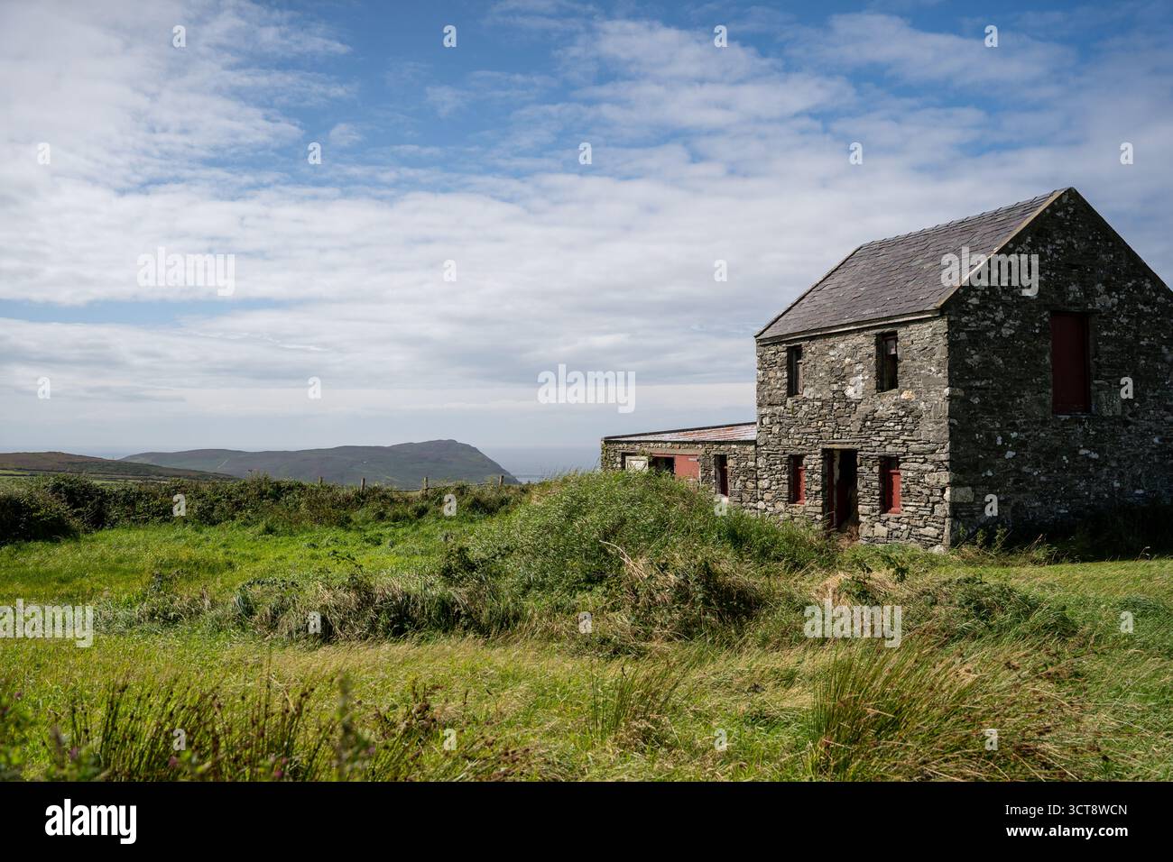 Ferme traditionnelle en pierre dans la campagne rurale de l'île de Man avec des collines Banque D'Images