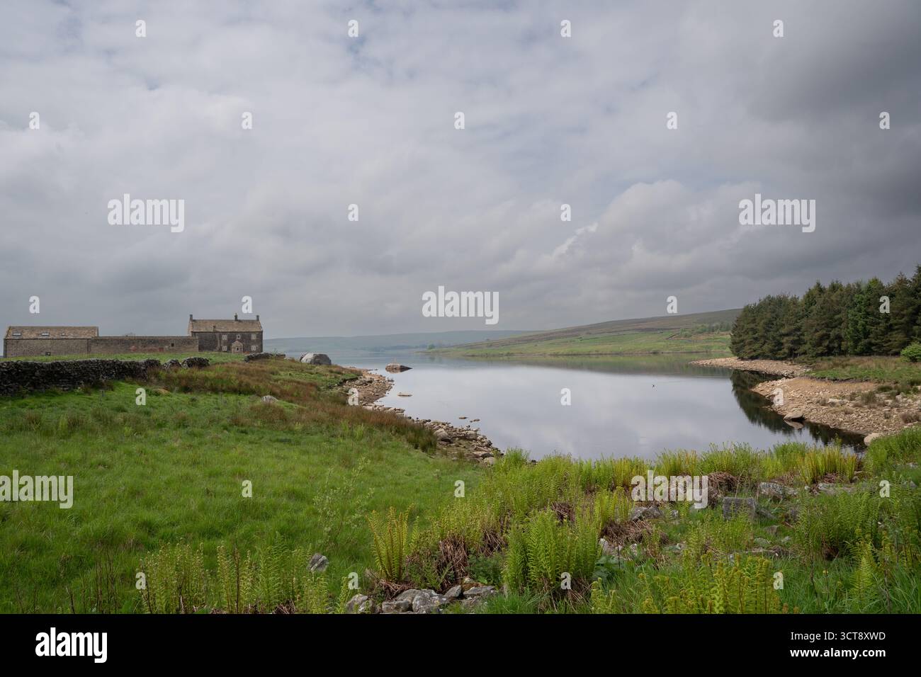 Réservoir paisible entouré d'une campagne verdoyante sous le ciel nuageux spectaculaire du Yorkshire Banque D'Images