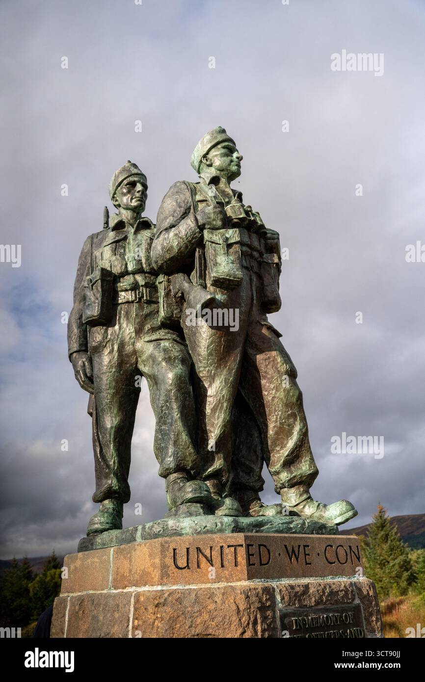 Statue commémorative de guerre en bronze de deux soldats avec l'inscription « United We Conquer » contre le ciel nuageux Banque D'Images