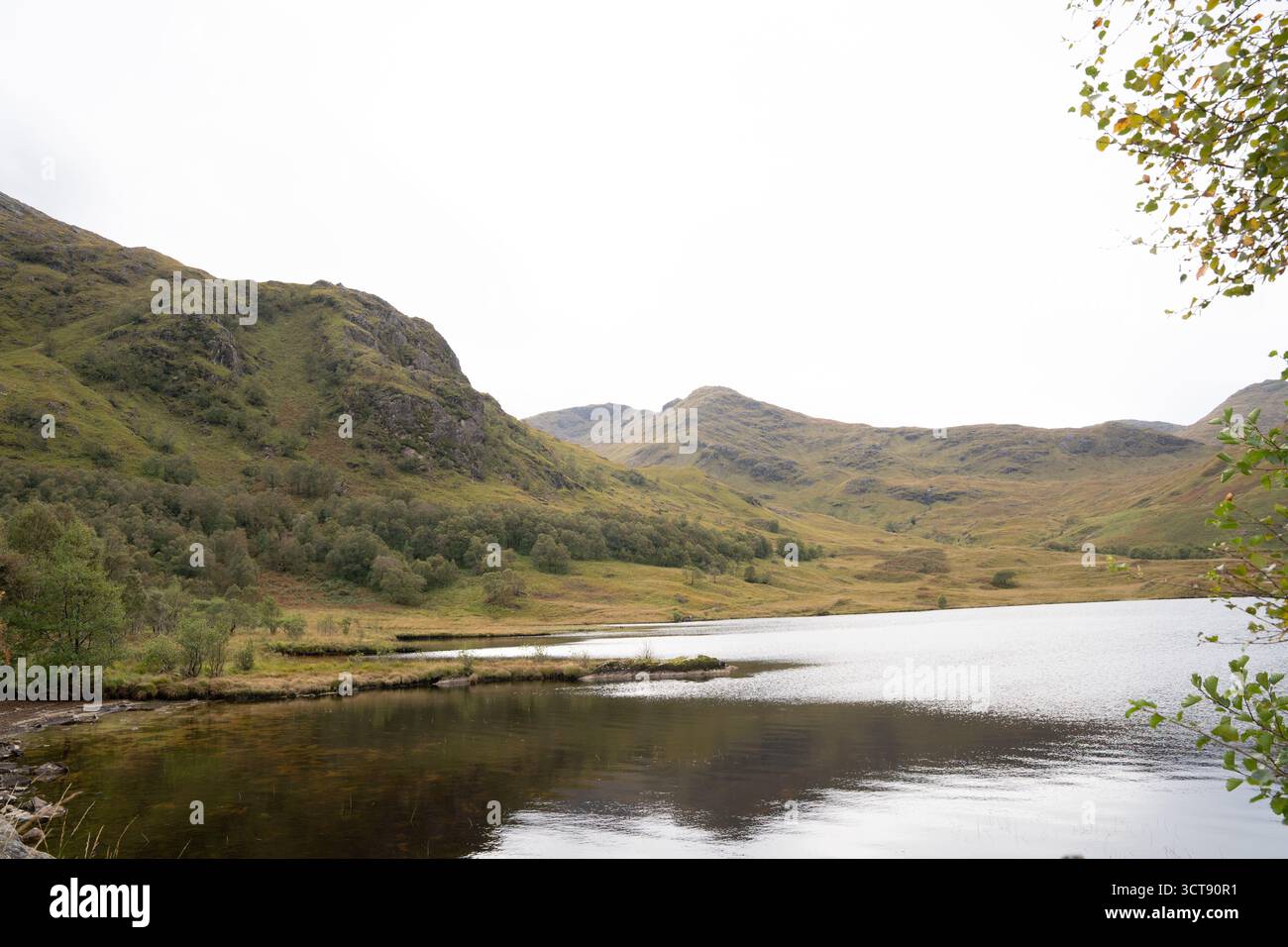 Paisible loch écossais entouré de collines verdoyantes et de montagnes dans les Highlands Banque D'Images