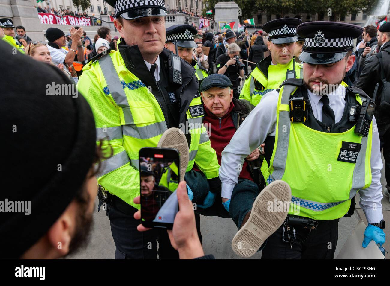 Londres, Royaume-Uni. 4 octobre 2025. Des policiers de la Metropolitan police arrêtent un manifestant qui avait une pancarte indiquant « je m'oppose au génocide, je soutiens l'action palestinienne » lors d'une veillée silencieuse de masse à Trafalgar Square organisée par Defend Our Jurys dans le cadre de sa campagne Lift the Ban contre la prohibition du groupe d'action directe Palestine action. Environ 1 000 personnes ont assisté à l'événement et la police métropolitaine, assistée de plusieurs autres forces de police, a procédé à 492 arrestations, dont 488 pour soutien à une organisation interdite. Crédit : Mark Kerrison/Alamy Live News Banque D'Images