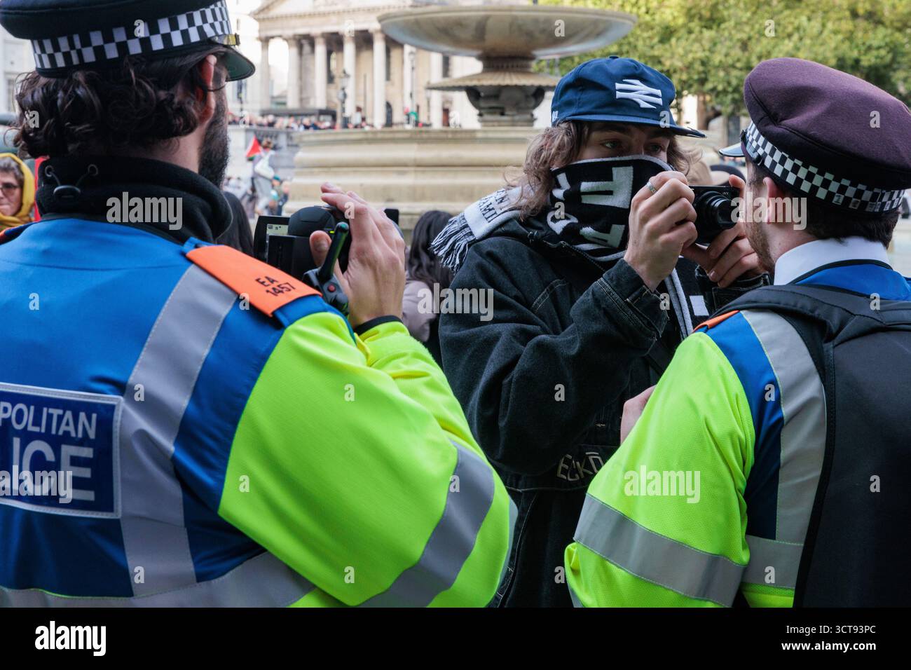 Londres, Royaume-Uni. 4 octobre 2025. Un manifestant avec une caméra affronte des officiers de la police métropolitaine lors d'une veillée silencieuse de masse à Trafalgar Square organisée par Defend Our Juries dans le cadre de sa campagne Lift the Ban contre l'interdiction du groupe d'action directe Palestine action. Environ 1 000 personnes ont assisté à l'événement et la police métropolitaine, assistée de plusieurs autres forces de police, a procédé à 492 arrestations, dont 488 pour soutien à une organisation interdite. Crédit : Mark Kerrison/Alamy Live News Banque D'Images