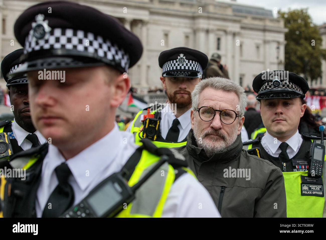 Londres, Royaume-Uni. 4 octobre 2025. Des policiers de la Metropolitan police arrêtent un manifestant qui avait une pancarte indiquant « je m'oppose au génocide, je soutiens l'action palestinienne » lors d'une veillée silencieuse de masse à Trafalgar Square organisée par Defend Our Jurys dans le cadre de sa campagne Lift the Ban contre la prohibition du groupe d'action directe Palestine action. Environ 1 000 personnes ont assisté à l'événement et la police métropolitaine, assistée de plusieurs autres forces de police, a procédé à 492 arrestations, dont 488 pour soutien à une organisation interdite. Crédit : Mark Kerrison/Alamy Live News Banque D'Images