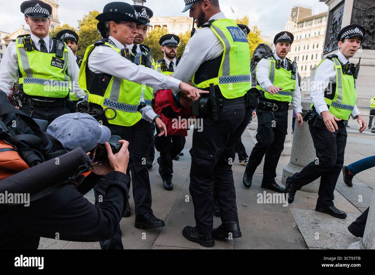 Londres, Royaume-Uni. 4 octobre 2025. Des policiers de la Metropolitan police arrêtent un manifestant qui avait une pancarte indiquant « je m'oppose au génocide, je soutiens l'action palestinienne » lors d'une veillée silencieuse de masse à Trafalgar Square organisée par Defend Our Jurys dans le cadre de sa campagne Lift the Ban contre la prohibition du groupe d'action directe Palestine action. Environ 1 000 personnes ont assisté à l'événement et la police métropolitaine, assistée de plusieurs autres forces de police, a procédé à 492 arrestations, dont 488 pour soutien à une organisation interdite. Crédit : Mark Kerrison/Alamy Live News Banque D'Images