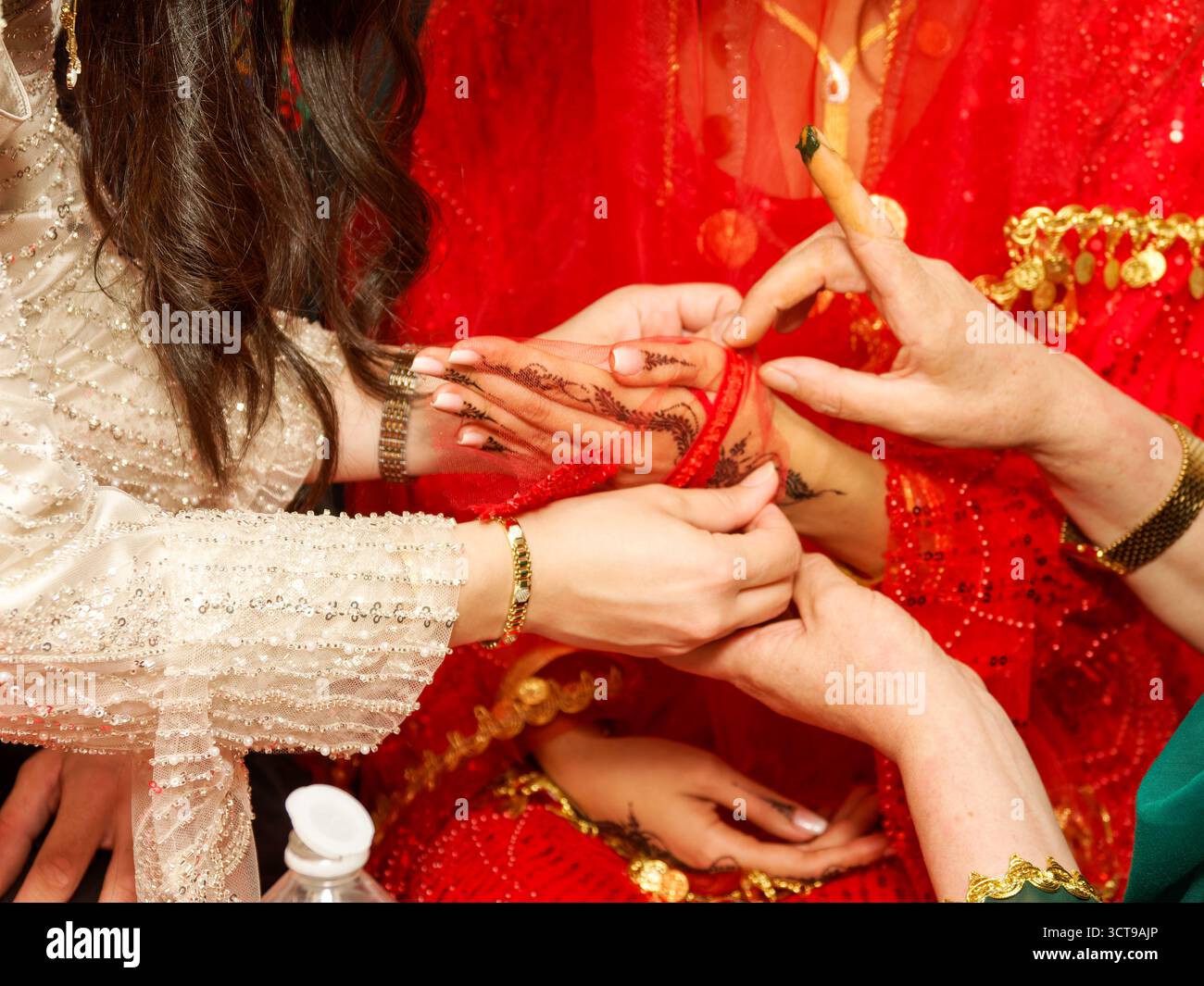Femme appliquant de la pâte de henné à la main de la mariée pendant la cérémonie kurde-tunisienne de pré-mariage. Banque D'Images