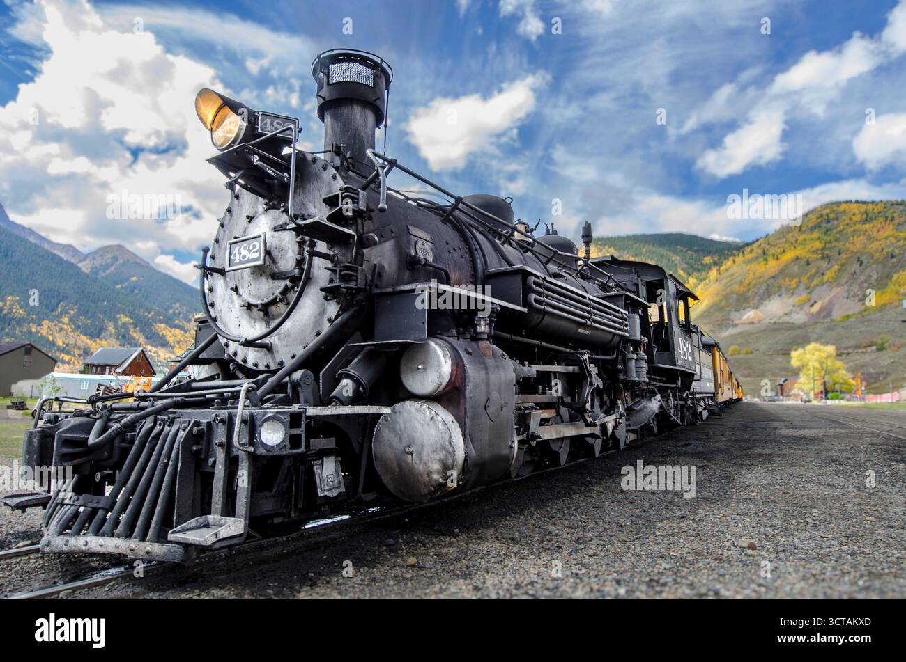 Locomotive à vapeur noire historique sur rails dans le paysage d'automne de la ville de montagne sous le ciel bleu Banque D'Images