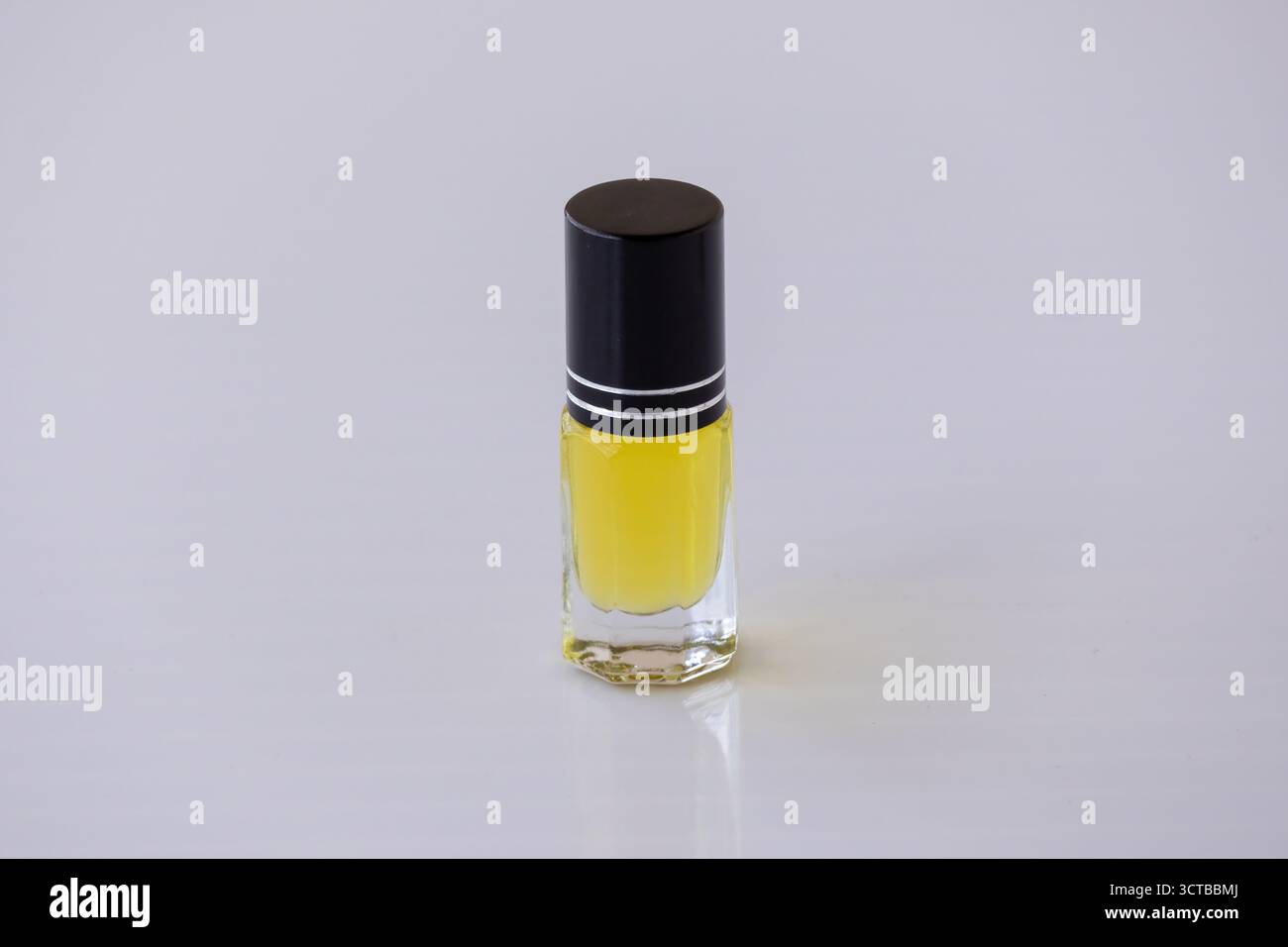 Gros plan d'une petite bouteille Attar en verre à roulettes, remplie d'huile de parfum arabe traditionnelle dorée. Parfum concentré pour les cadeaux de luxe et l'arôme Banque D'Images