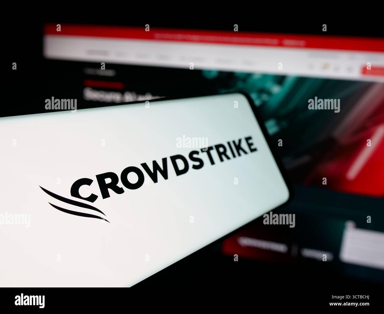Dans cette illustration photo, un smartphone avec le logo de la société de cybersécurité CrowdStrike Holdings est vu sur l'écran devant le site Web. Banque D'Images