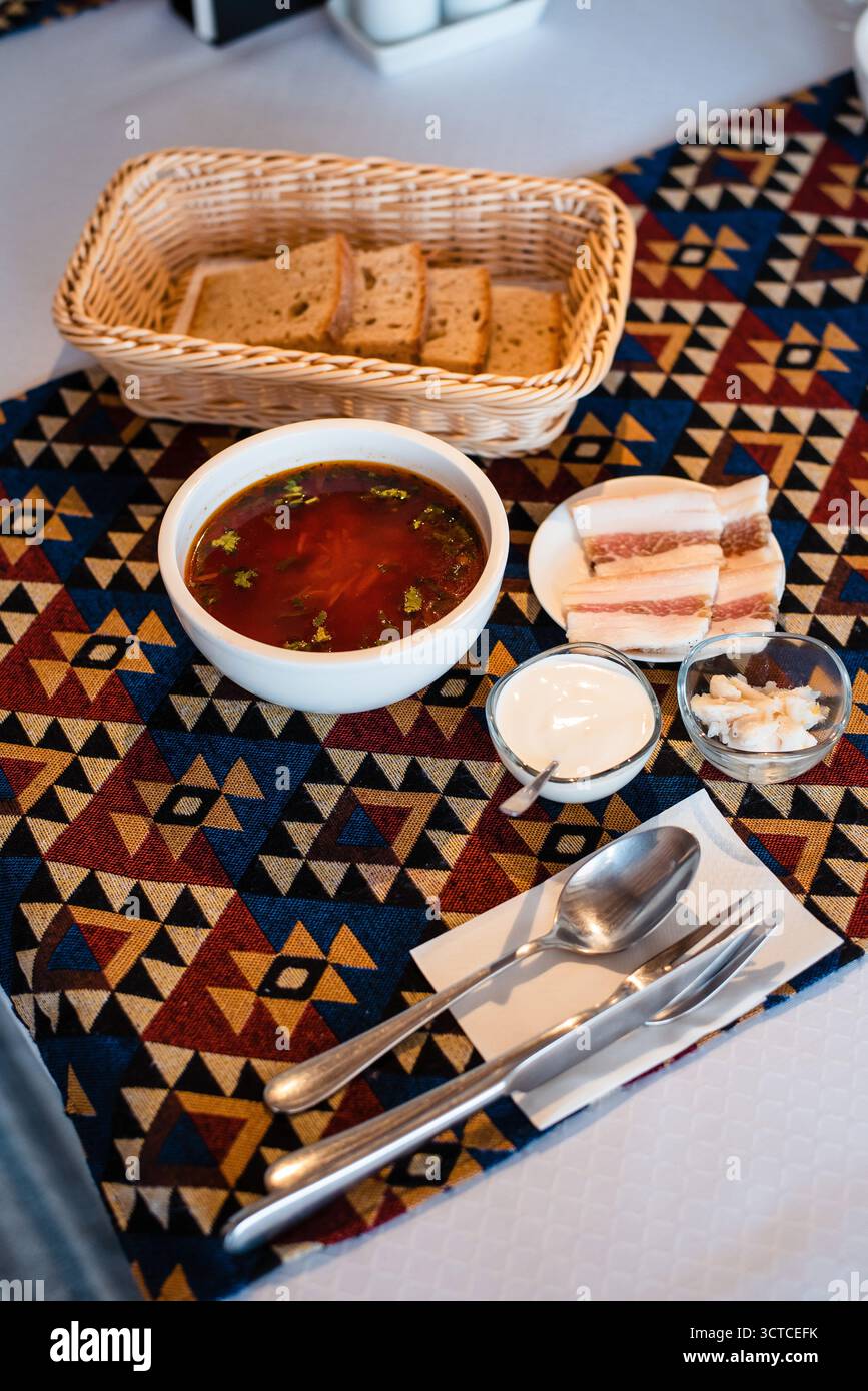 Soupe et pain au bacon sur nappe à motifs Banque D'Images Soupe et pain au bacon sur nappe à motifs Banque D'Images