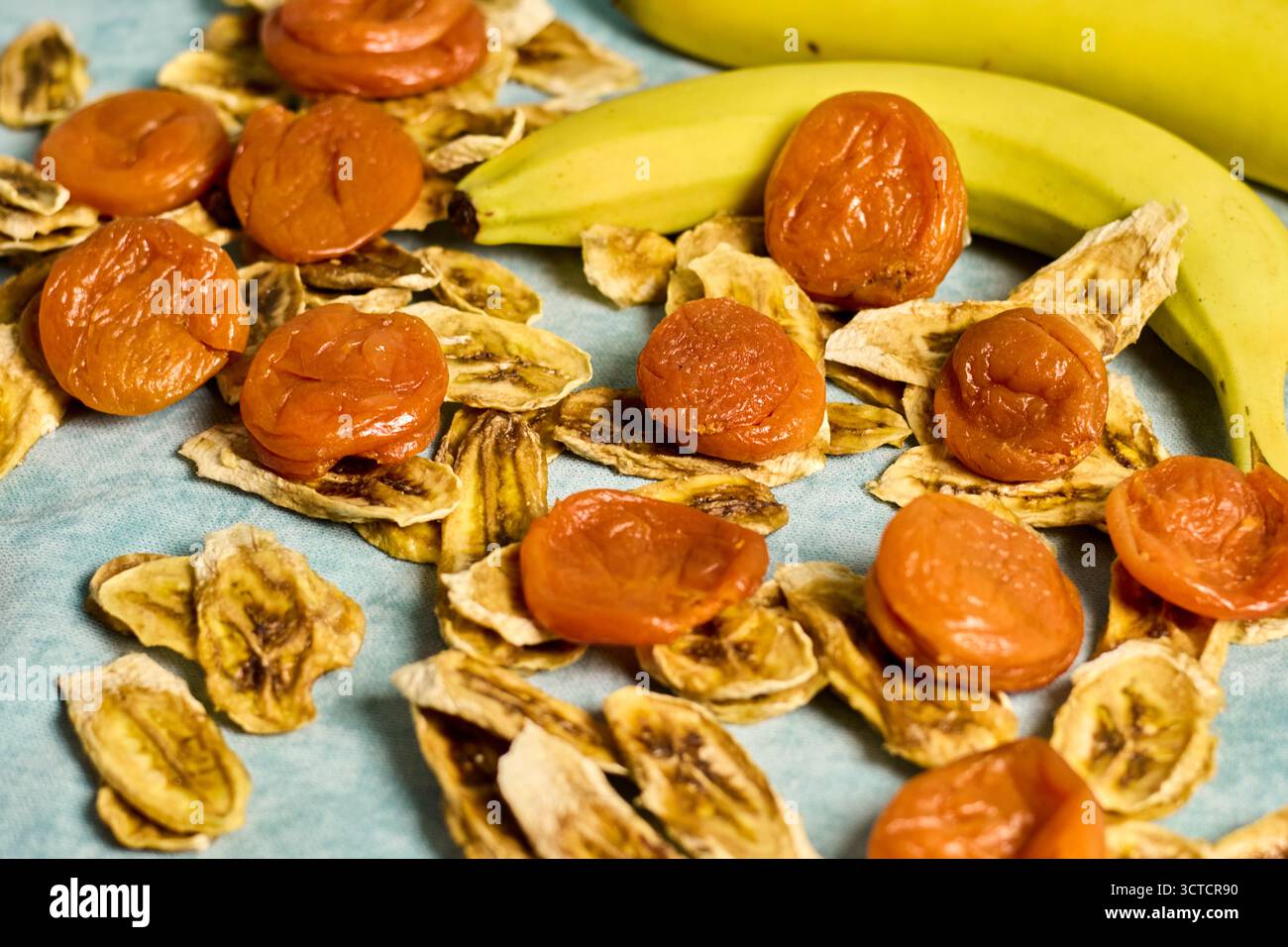 Les abricots séchés et les chips de banane, une collation saine et savoureuse, offrent un éclat de douceur naturelle et d'énergie, parfait pour profiter à tout moment de la journée Banque D'Images