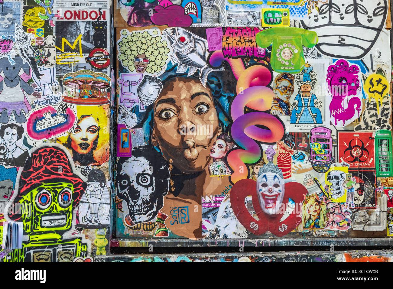 Mur recouvert de graffitis colorés et d'autocollants à Brick Lane, East London, Royaume-Uni Banque D'Images