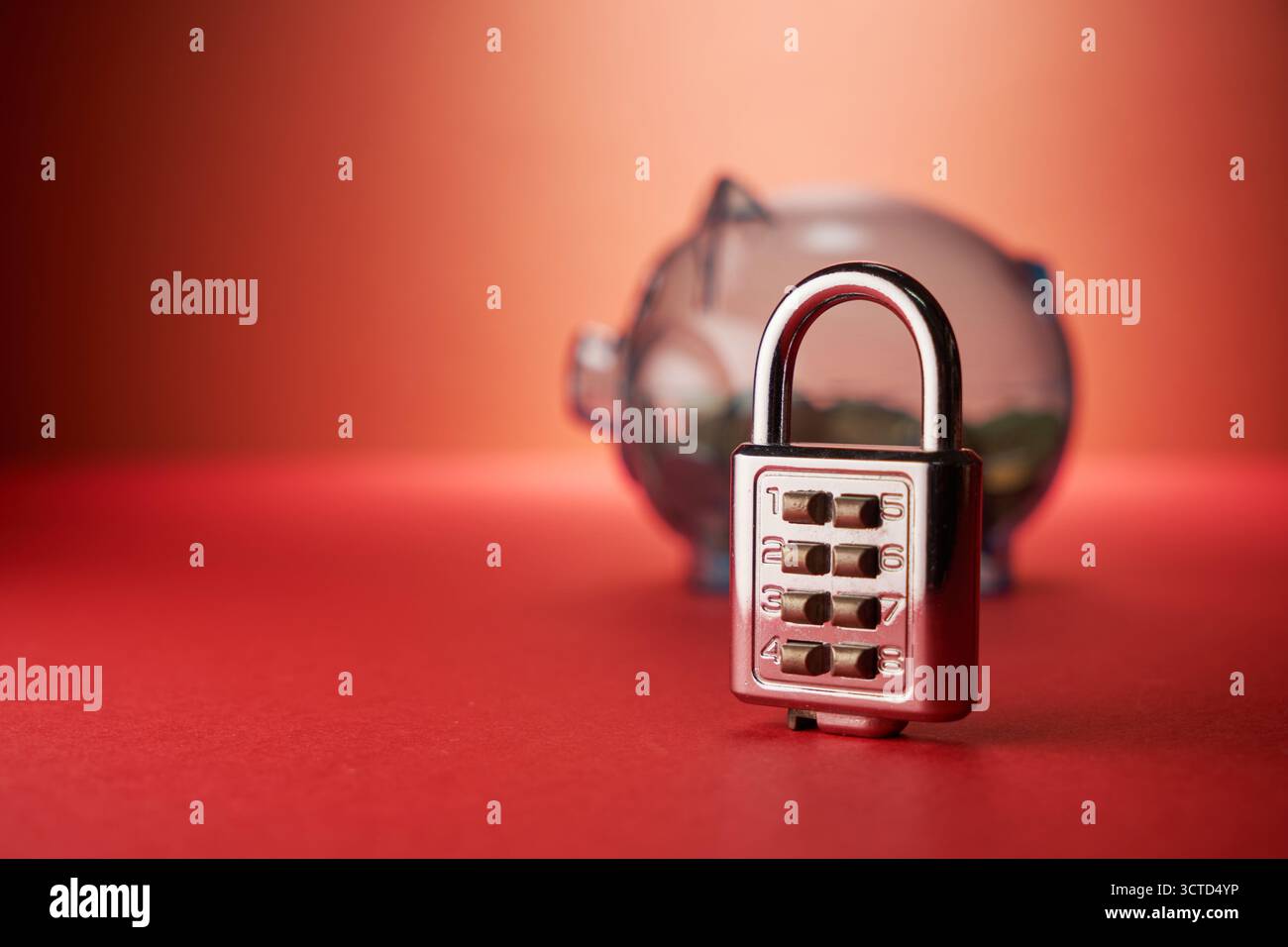 Cadenas et tirelire bleue avec fond de mur rouge. Protection des économies, Banque D'Images