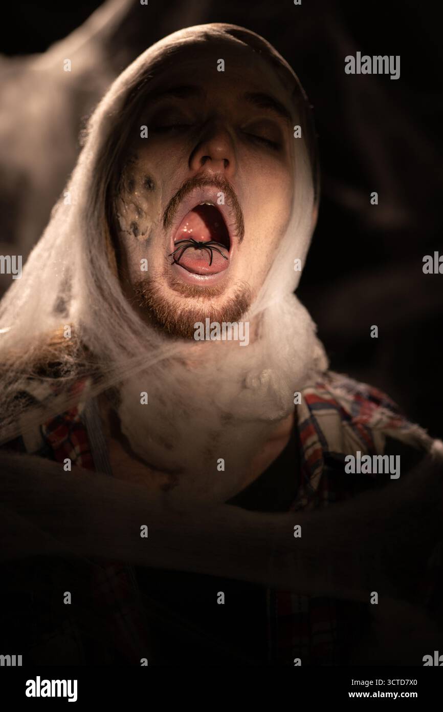 Homme zombie dans des toiles d'araignée avec le visage fantôme effrayant, concept d'halloween. copier l'espace Banque D'Images