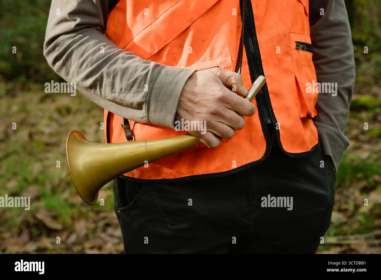 Gros plan de la main d'un chasseur tenant un pibole rond, un cor de chasse utilisé pendant la chasse Banque D'Images