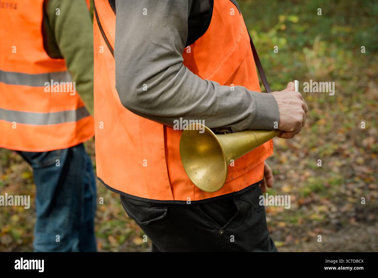 Gros plan de la main d'un chasseur tenant un pibole rond, un cor de chasse utilisé pendant la chasse Banque D'Images