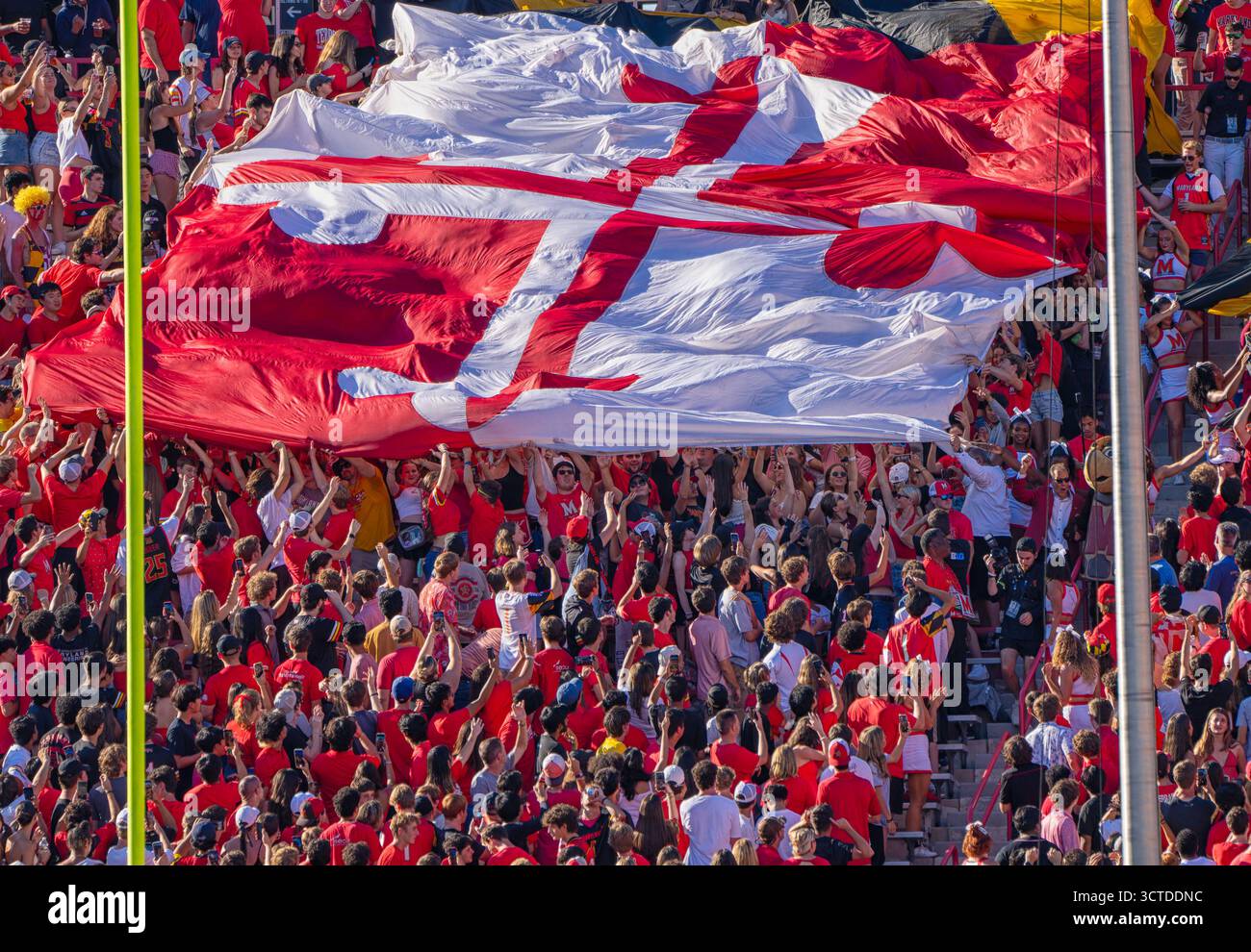 Les fans d'un match de football déploient un drapeau géant Banque D'Images