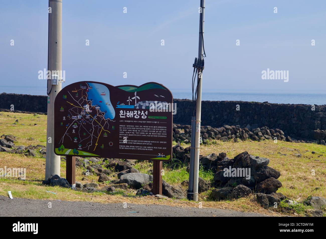 Un panneau d'information explique les murs de défense côtière de Hwanhaejangseong près de Handong, situés devant de longs murs de champs de basalte qui bordent ce tronçon de je Banque D'Images