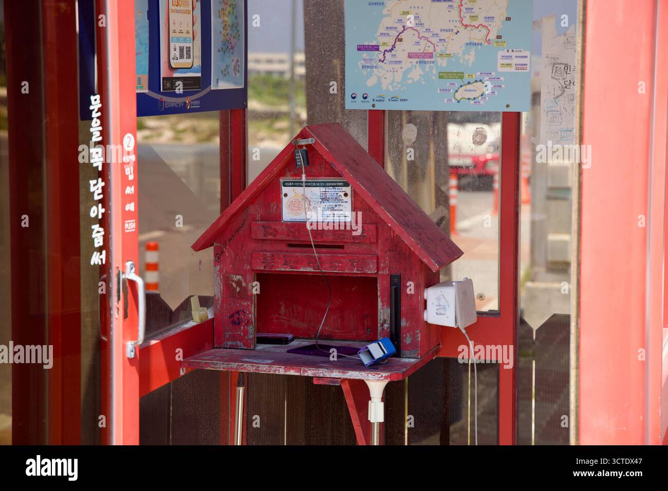 L’intérieur du centre de certification de la plage de Gimnyeong Seongsegi montre la boîte rouge, le tampon encreur et les cartes utilisées par les cyclistes qui complètent la côte de Jeju Banque D'Images