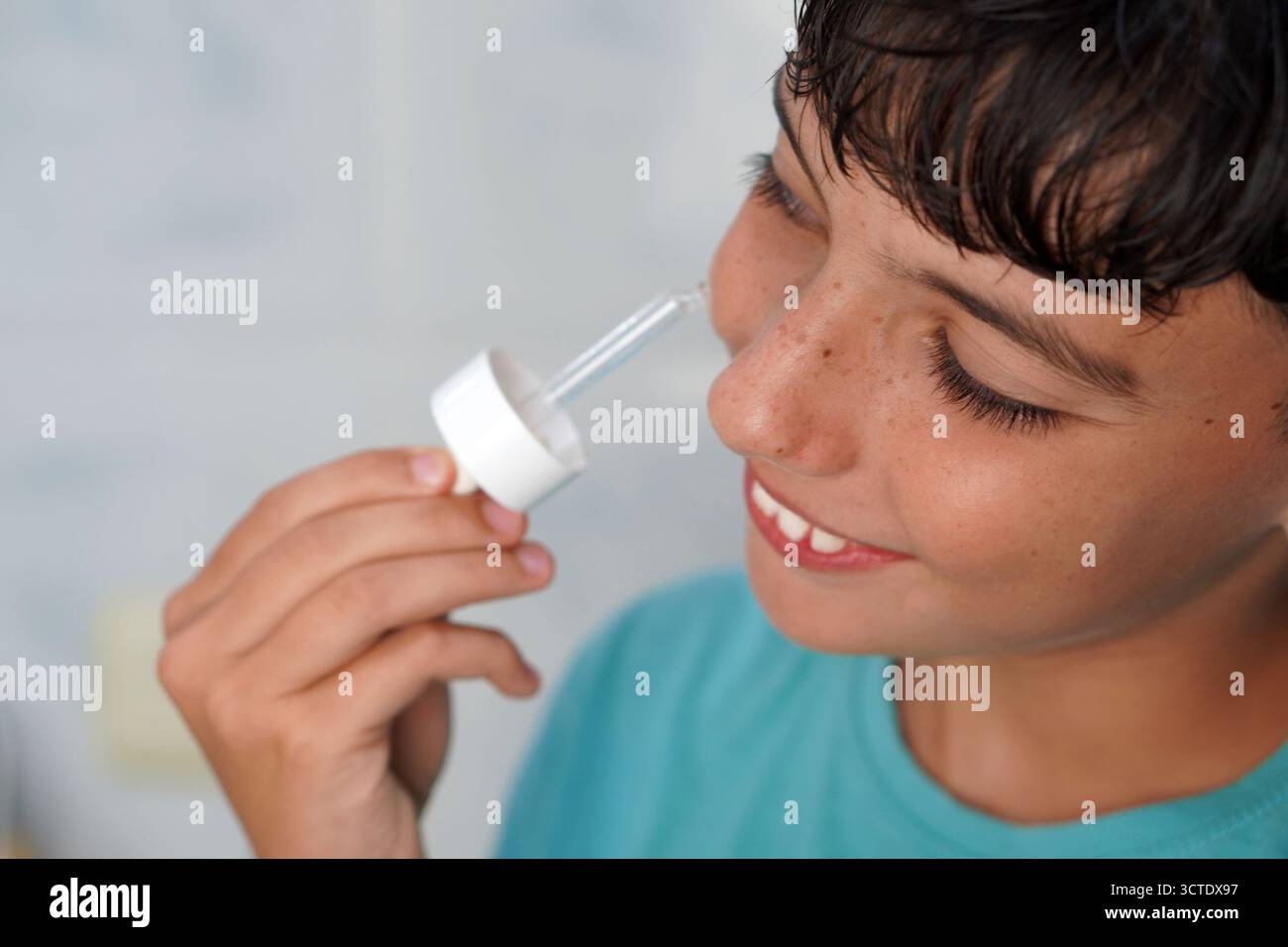 adolescence et soins de la peau. Adolescent appliquant du sérum sur sa peau. Banque D'Images