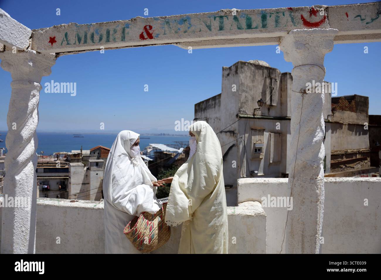 Alger, Algérie. 25 mai 2025. Photo prise le 25 mai 2025, montrant des filles vêtues de vêtements traditionnels (haik) dans la vieille ville d'Alger, la Casbah, désignée par l'UNESCO. Le haik est un symbole d’élégance, d’identité et de résistance pour les femmes algériennes. Photo de Billel Bensalem/APP/ABACAPRESS.COM crédit : Abaca Press/Alamy Live News Banque D'Images