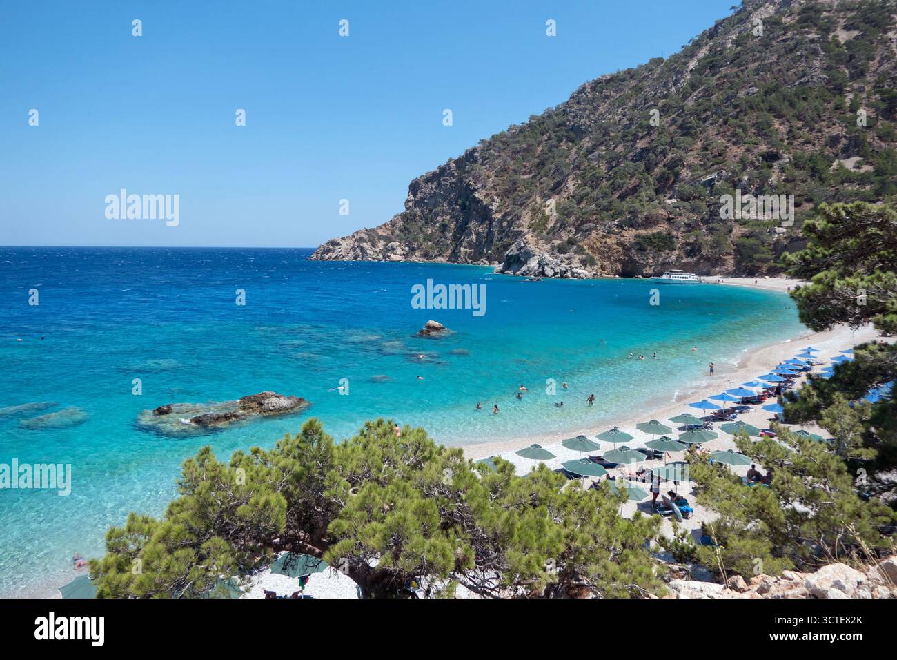 Vue de la plage d'Apella sur l'île de Karpathos dans la mer Égée, Grèce. Destination grecque sur la mer Méditerranée avec des gens et des touristes nageant Banque D'Images