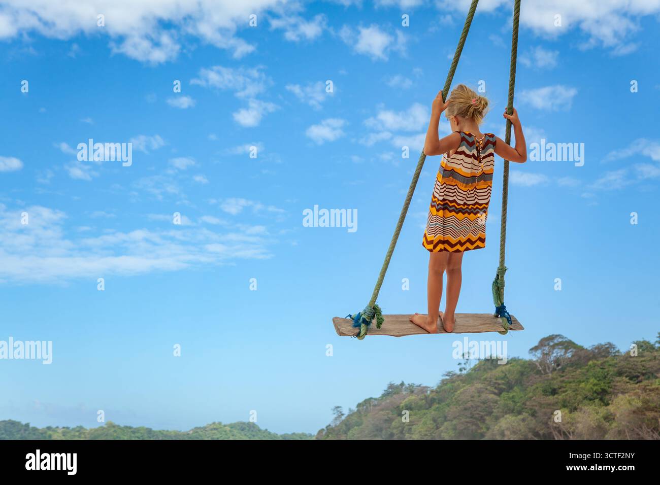 Happy girl amusez swinging élevée dans l'air. Voler à l'envers sur la corde swing sur mer plage. Aventure Voyage au paradis tropical island. L Famille Banque D'Images