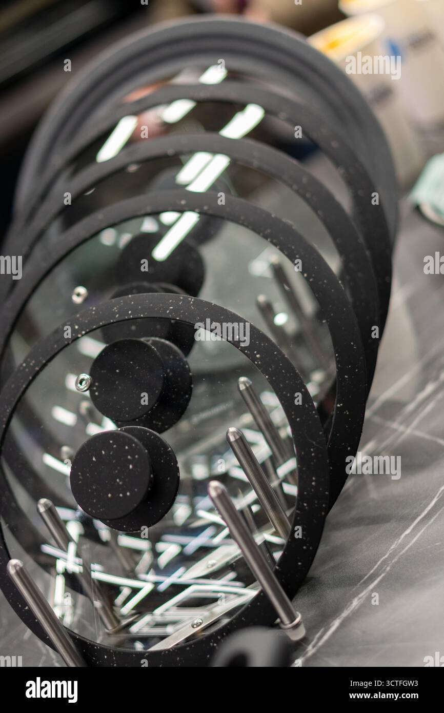 Couvercles en verre de différentes tailles sur un support dans une salle d'exposition de magasin d'appareils de cuisine. Banque D'Images