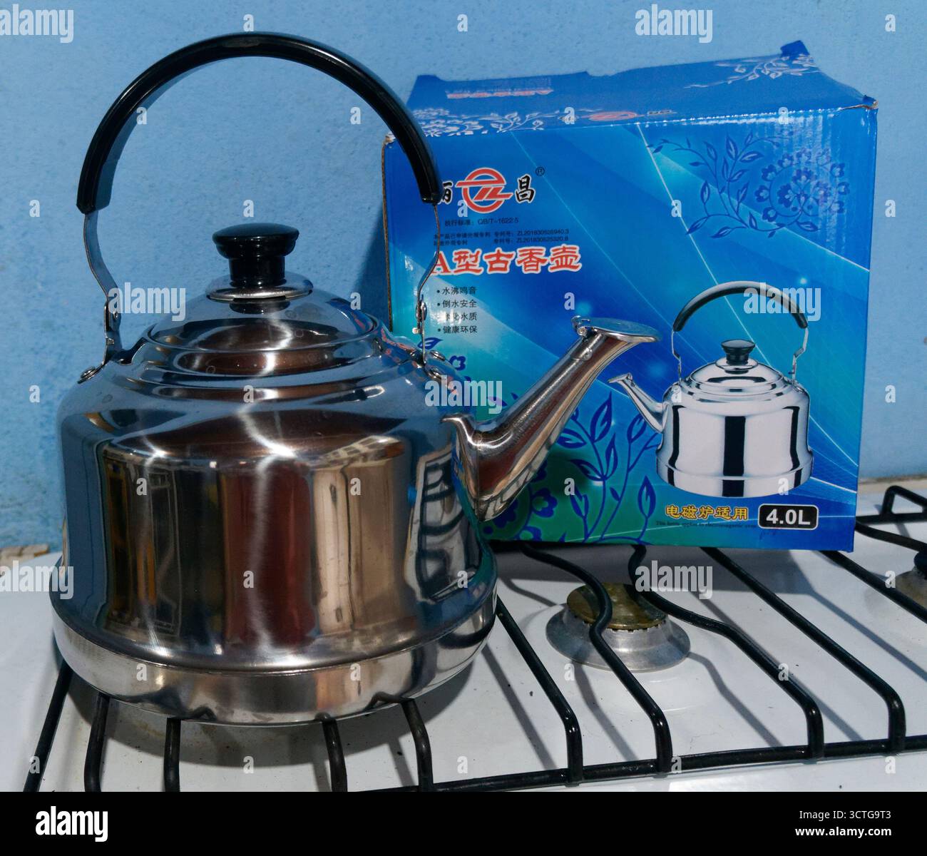 Bouilloire chinoise de 4 litres pour tous les poêles avec carton à l'arrière assis sur la table de cuisson à gaz Banque D'Images