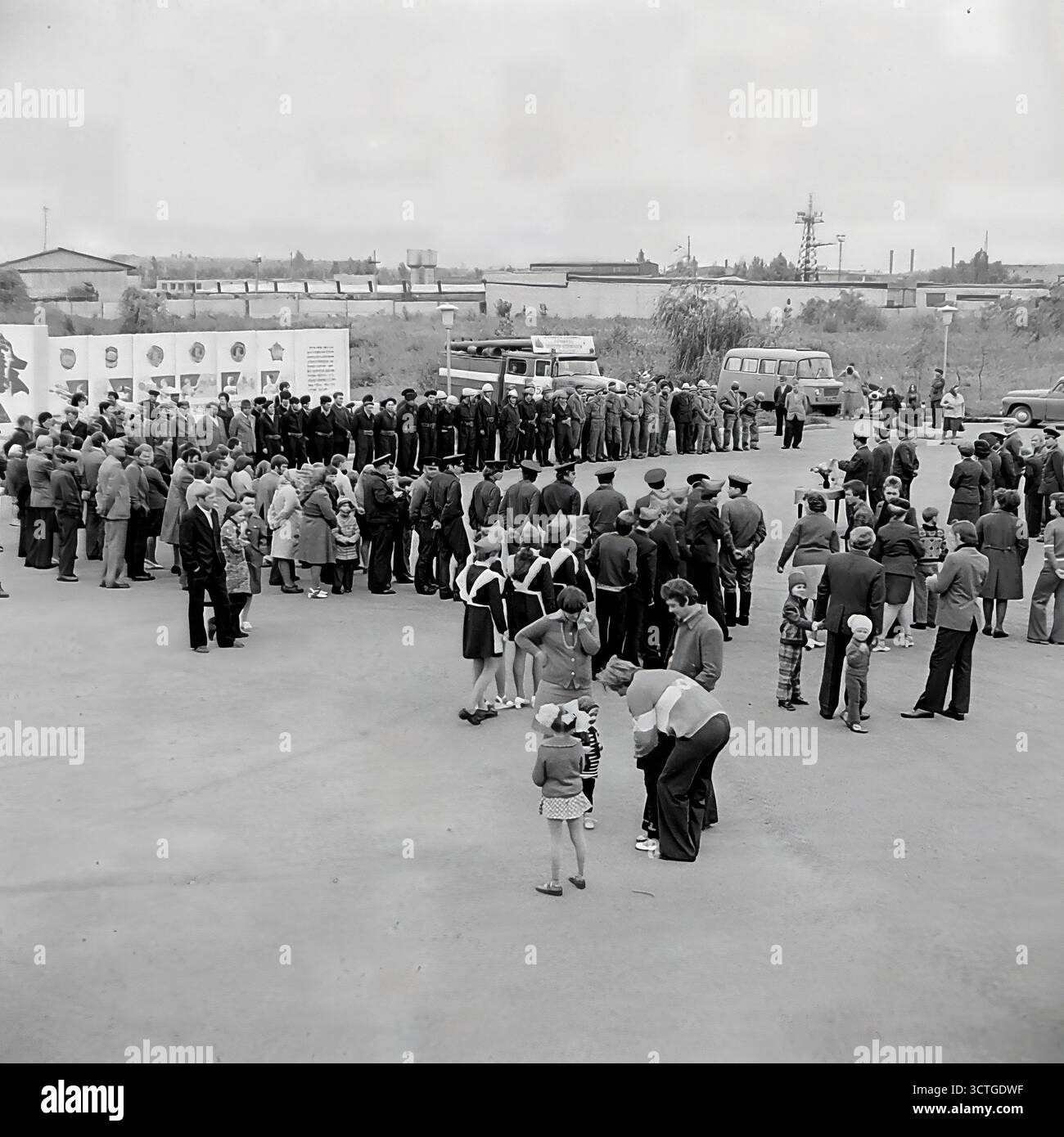 Un exercice de formation des pompiers et une manifestation publique dans le parc Lénine (aujourd'hui parc Shovkovychnyi) dans les années 1970 Sloviansk, RSS d'Ukraine. Les photos capturent à la fois l'action d'éteindre un incendie et une liste formelle de pompiers pour le public. Une grande foule de spectateurs civils, y compris des écoliers, assiste à l'événement. Cet exercice a servi à la fois d'exercice professionnel pour les pompiers et d'événement important de sécurité publique, mettant en valeur l'état de préparation des services d'urgence soviétiques à la communauté locale Banque D'Images