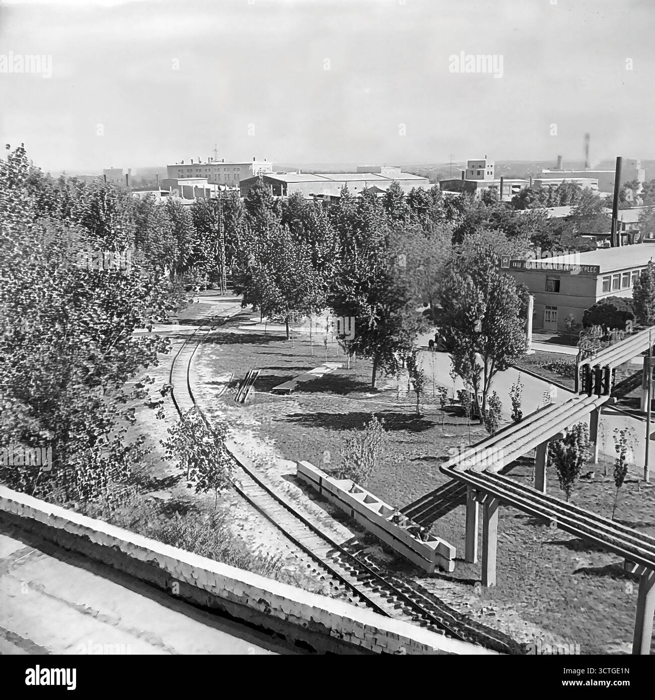 Le territoire de l'usine 'Keram Mash' (machines en céramique) dans les années 1970 Sloviansk, RSS d'Ukraine. Les photos montrent une entreprise soviétique classique, qui était à la fois un site industriel et un espace social paysager. Un bâtiment est arboré du slogan emblématique, "en avant de la victoire du communisme !" tandis que le terrain dispose d'un parc avec des arbres et des chemins. Les infrastructures industrielles, comme un embranchement ferroviaire et des pipelines, sont intégrées dans la zone verte. Cela représente l'idéal de l'usine soviétique comme un monde complet pour ses ouvriers. Banque D'Images