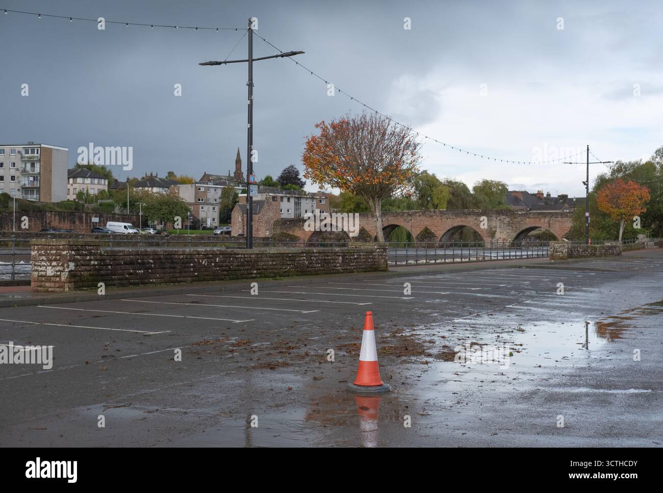 4 octobre 2025, Whitesands à la suite de la tempête Amy, un cône de circulation solitaire se trouve dans un parking déserté et souillé. Centre-ville de Dumfries, Écosse. Banque D'Images