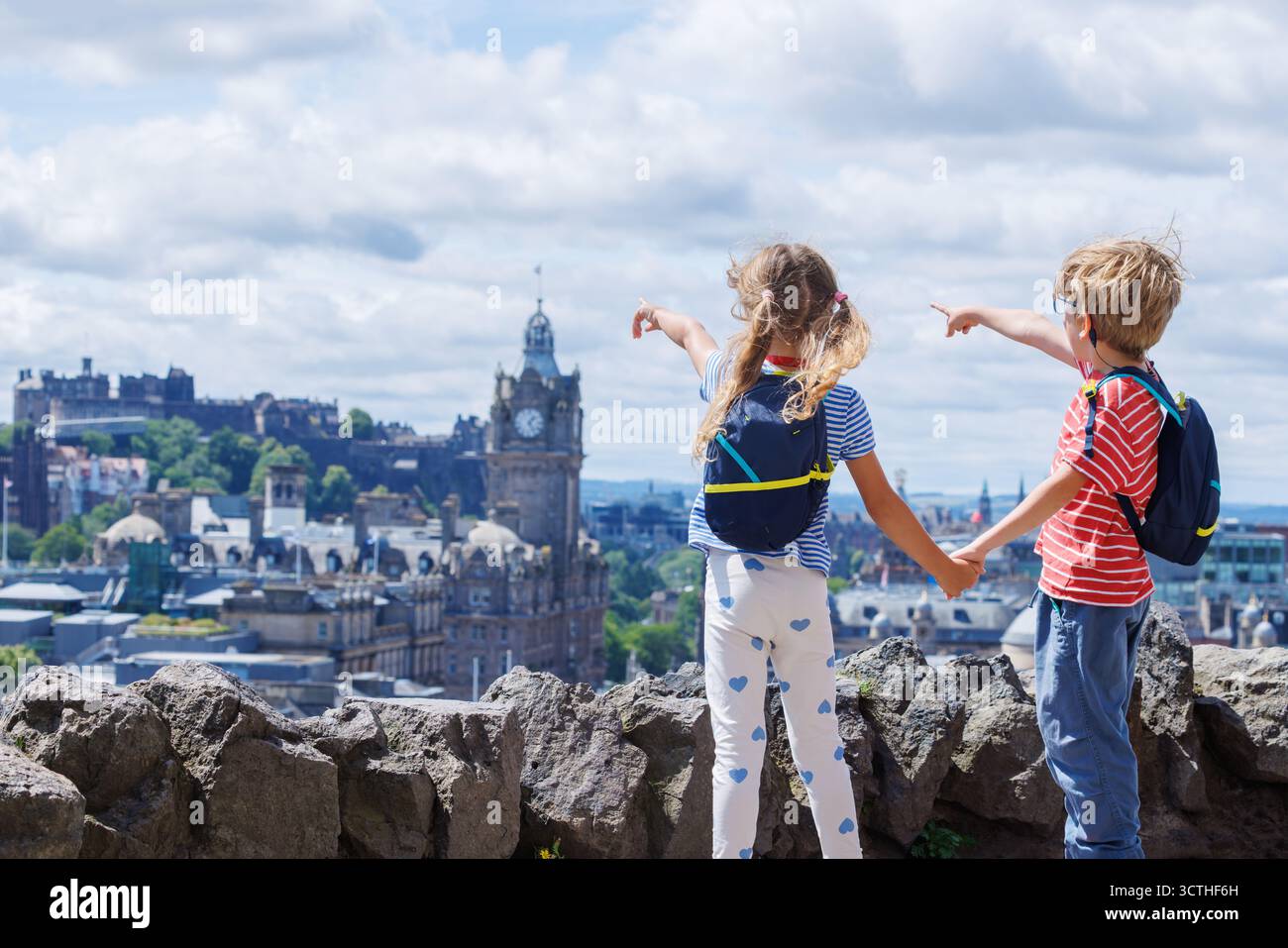 Les enfants touristes apprécient la vue panoramique sur la ville, se tenant la main Banque D'Images