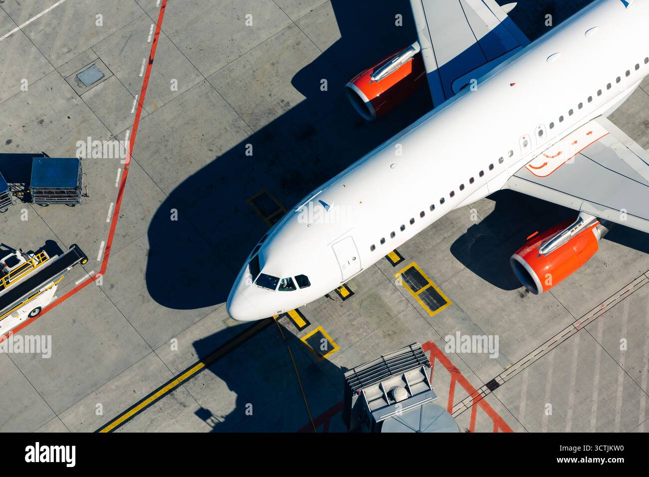 Vue aérienne de l'avion blanc à l'aéroport. Avion devant la passerelle d'embarquement des passagers depuis le terminal. Banque D'Images